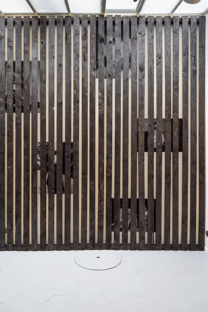 alicia-zaton-za-2014-2015-installation-en-brois-brule-a-la-dimension-du-mur-de-la-galerie-poster-d-archives-personnelles-colle-au-mur-derrieres-des-lattes-de-bois-590x370cm-df82904d0fd4b5492dc64cc7e2e2e4e9